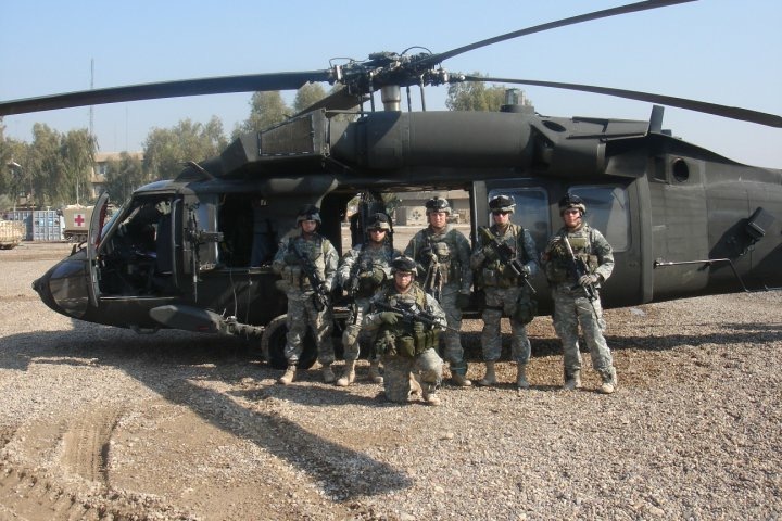 Jonny Langford with fellow soldiers in front of military helicopter